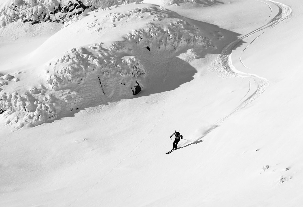 PERSON SKIING ON SNOWCAPPED MOUNTAIN