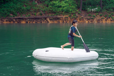 Man standing on boat in lake