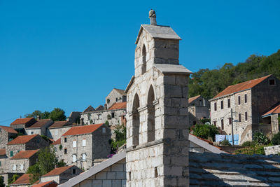 Low angle view of buildings against clear blue sky
