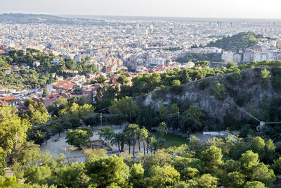 Aerial view of cityscape and trees against sky