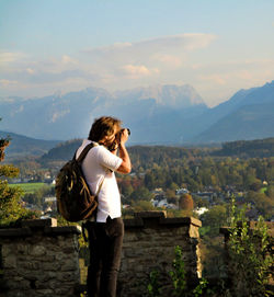 Side view of man photographing during sunset