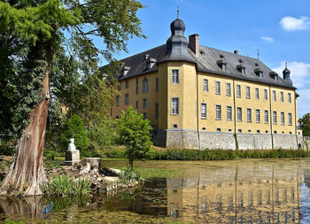 Building by lake against sky