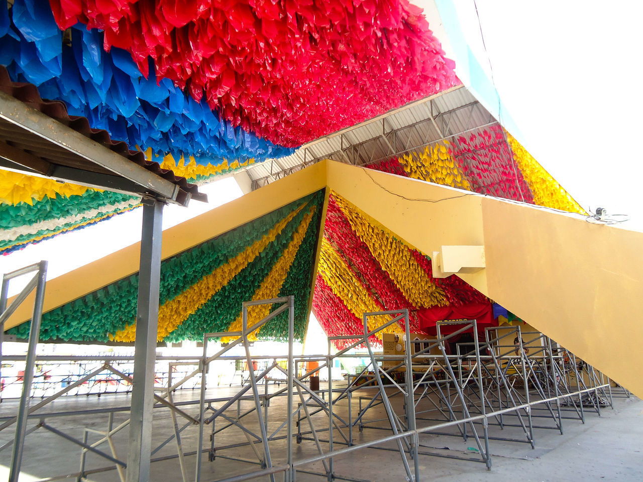 LOW ANGLE VIEW OF MULTI COLORED UMBRELLAS ON ROOF