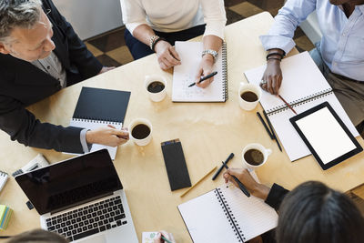 High angle view of business people discussing on table in office