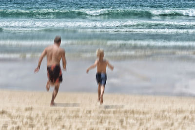 Rear view of men on beach