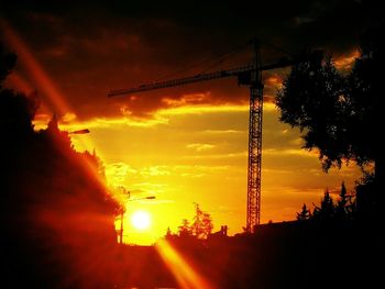 Silhouette of electricity pylon at sunset