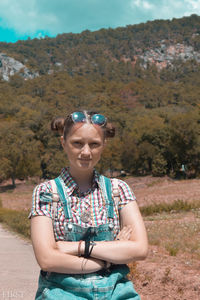 Portrait of beautiful young woman standing on land