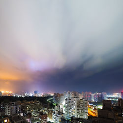 High angle view of illuminated buildings against sky at night