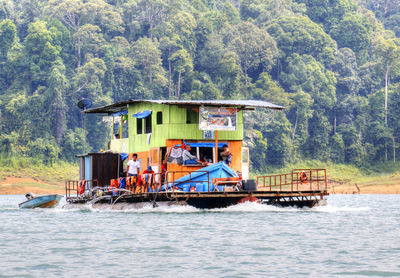 Ship in water against trees