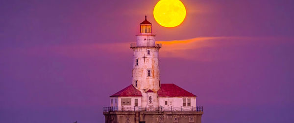 Lighthouse by sea against sky during sunset ,chicago city,usa