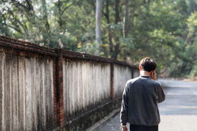 Rear view of man walking on road