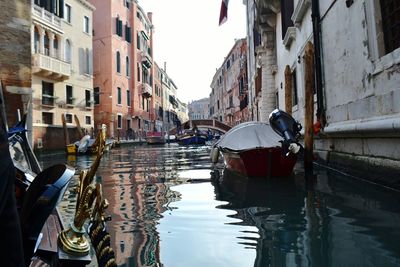 Boats moored in canal along buildings