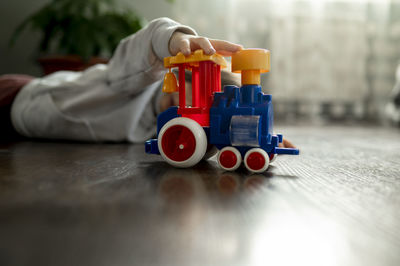 Boy lying on floor and playing with toy train