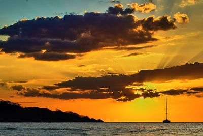 Scenic view of sea against dramatic sky during sunset