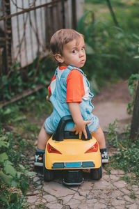 Portrait of cute boy sitting in toy car