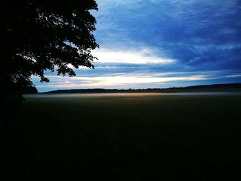 Scenic view of field against sky at sunset