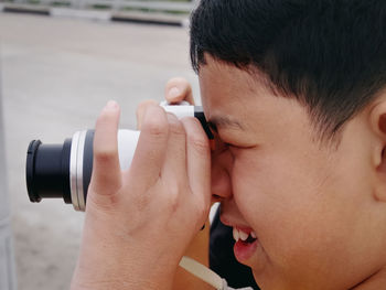 Close-up shot of kid taking photos with mirrorless camera