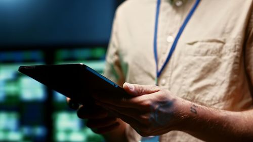 Midsection of man using mobile phone