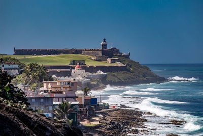 Houses on coast with fort in background