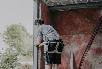 Caucasian male builder clean the window opening.