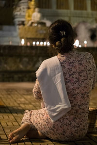 Rear view of woman sitting outdoors