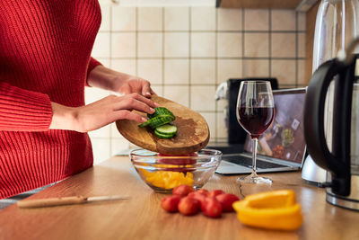 Close-up of the hands of a girl preparing a salad according to a video recipe. cooking courses 