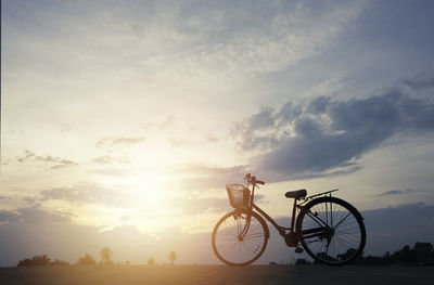 Silhouette bicycle against sky during sunset