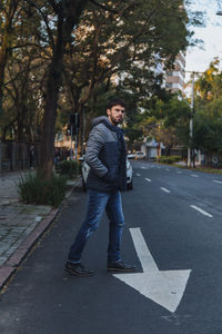 Young man walking on road in city