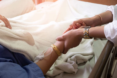 Midsection of couple holding hands