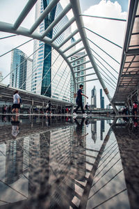 People walking on footbridge in city