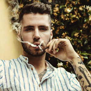 Portrait of young man smoking cigarette