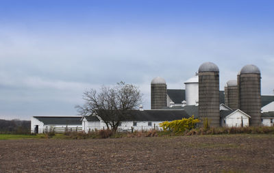 Old barn on field against sky