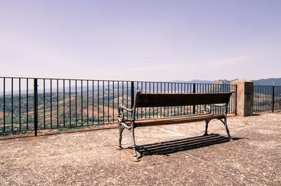 Empty chairs on field against clear sky