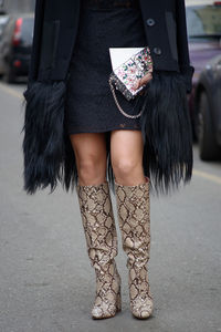 Low section of woman standing on footpath