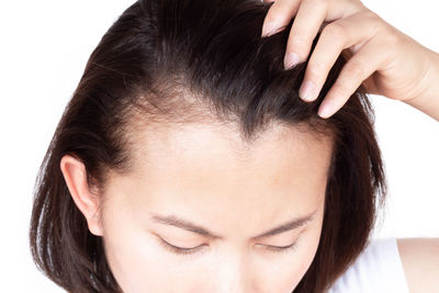 Close-up portrait of a young woman over white background