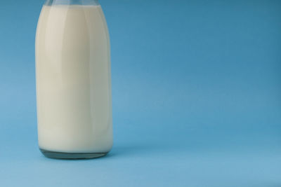 Close-up of white bottle against blue background