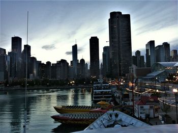 View of boats moored in city at sunset