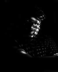 Portrait of young man sitting in darkroom