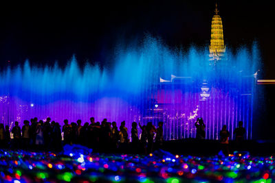 Group of people at illuminated building at night