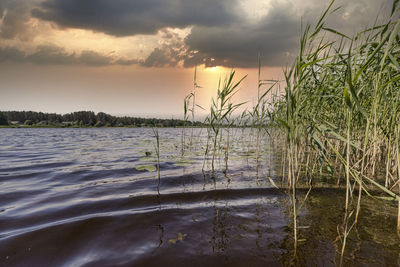 Scenic view of lake against sky at sunset