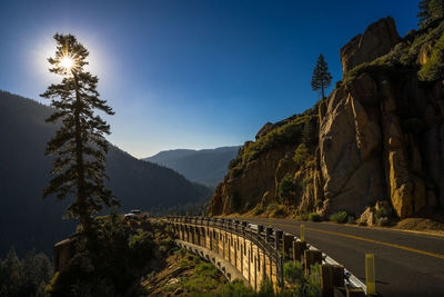 Panoramic shot of road by mountain against clear sky