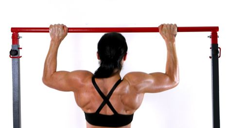 Rear view of woman with arms raised standing against white background