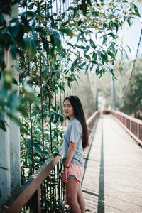 Portrait of woman standing on footbridge