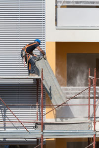 Men working at construction site against building