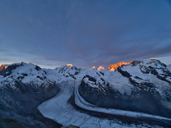 Scenic view of snowcapped mountains against sky during sunrise 