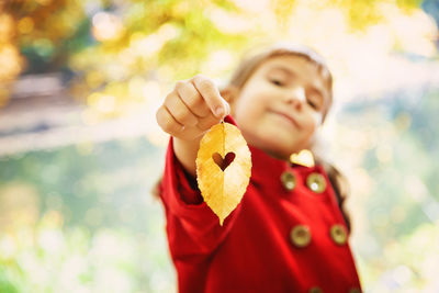 Girl holding leaf with heart shape