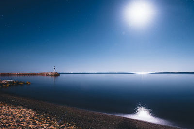 Scenic view of sea against clear sky at night