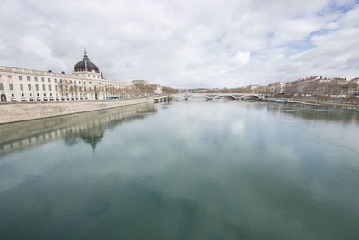 Bridge over rhône river by buildings against sky in lyon