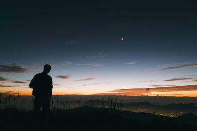 Silhouette of woman looking at sunset