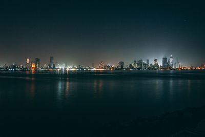 Illuminated city against clear sky at night